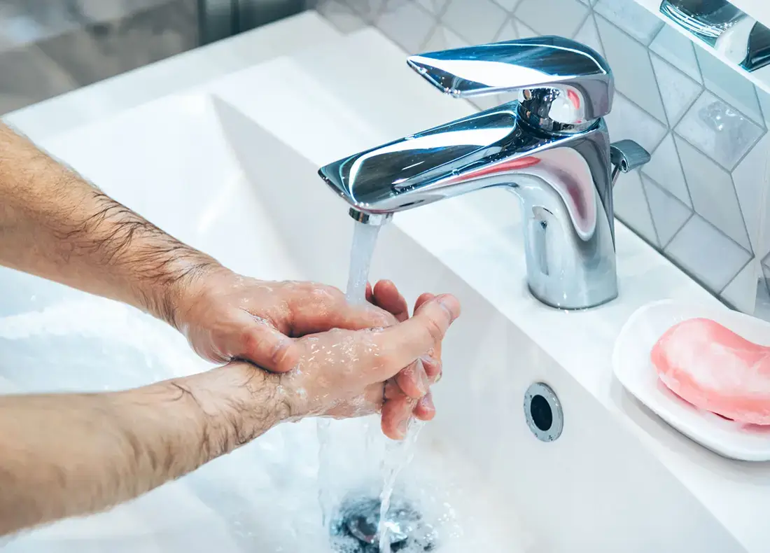 Low water pressure - man is washing hands with soap